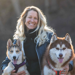 Face of a woman called Tess and two huskies